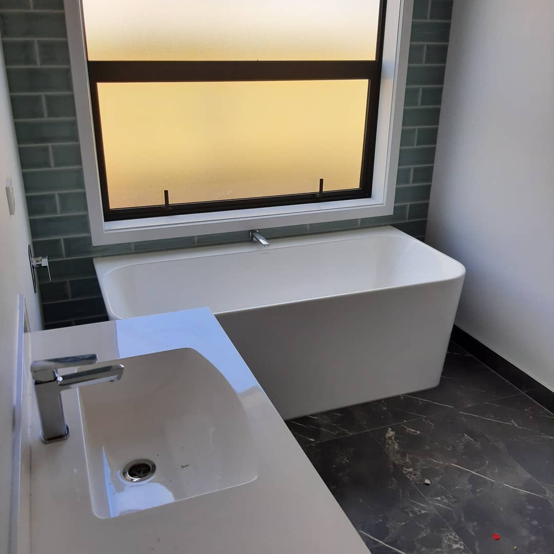 Completed bathroom renovation with freestanding bath and vanity